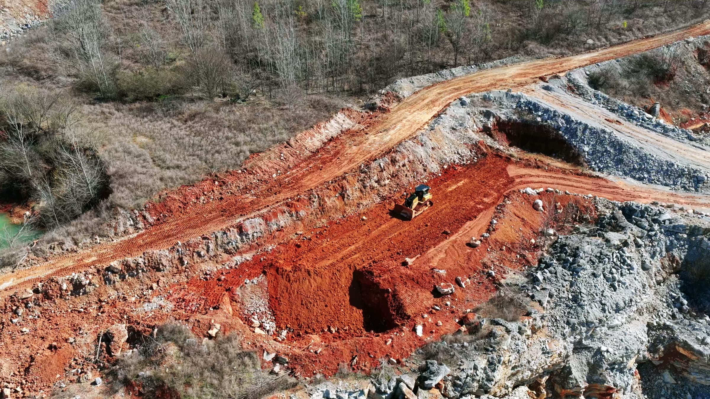 Aerial view of an excavator working a red-earth mine cut